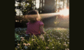 young girl looking at sunset through a forest